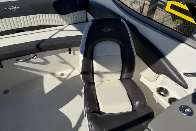 Slide: The Image of 2019 Stingray 198 LX boat interior with black and white seating and cup holders. - 19