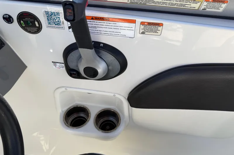 Slide: The Image of 2019 Stingray 198 LX boat control panel with throttle and cup holders. - 27