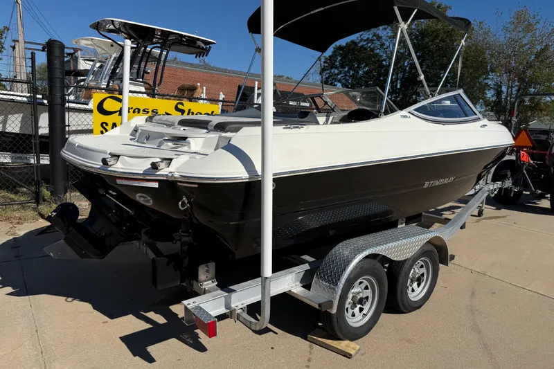 Slide: The Image of 2019 Stingray 198 LX boat on trailer, displayed outdoors under clear sky. - 3