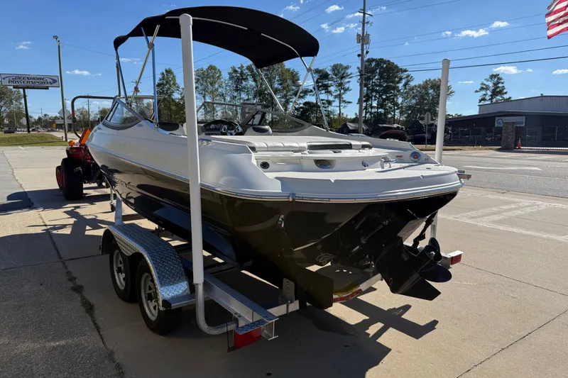 Slide: The Image of 2019 Stingray 198 LX boat on trailer, parked outdoors under clear sky. - 5