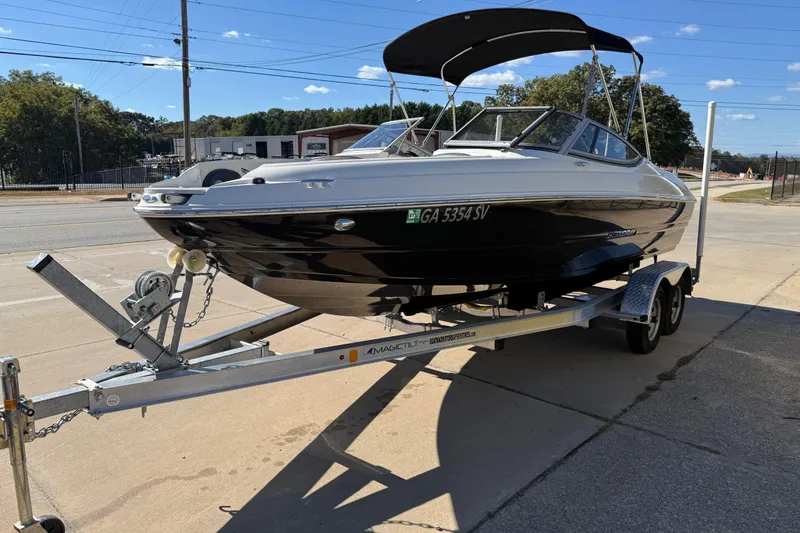 Slide: The Image of 2019 Stingray 198 LX boat on trailer, parked outdoors under clear sky. - 6