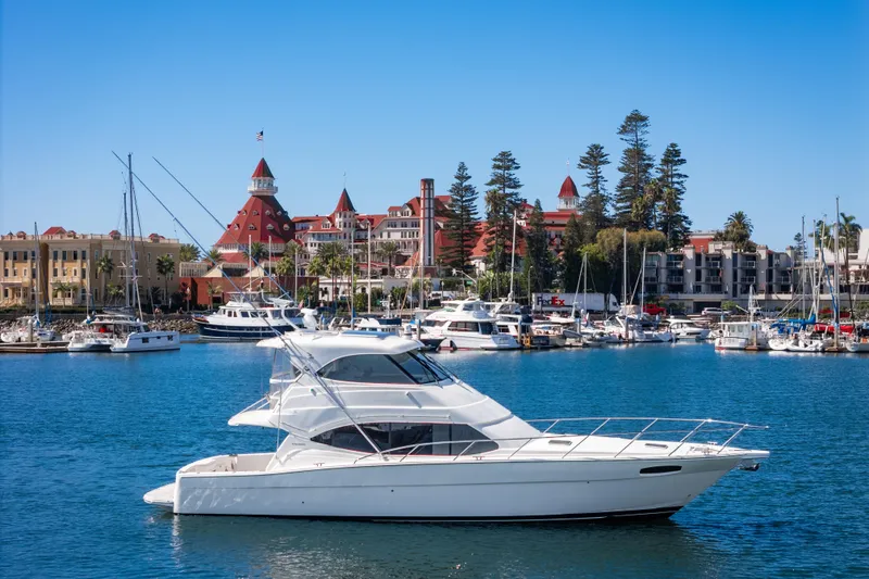 The Image of 2014 Maritimo 470 Offshore Convertible yacht in scenic marina with historic buildings. - 0