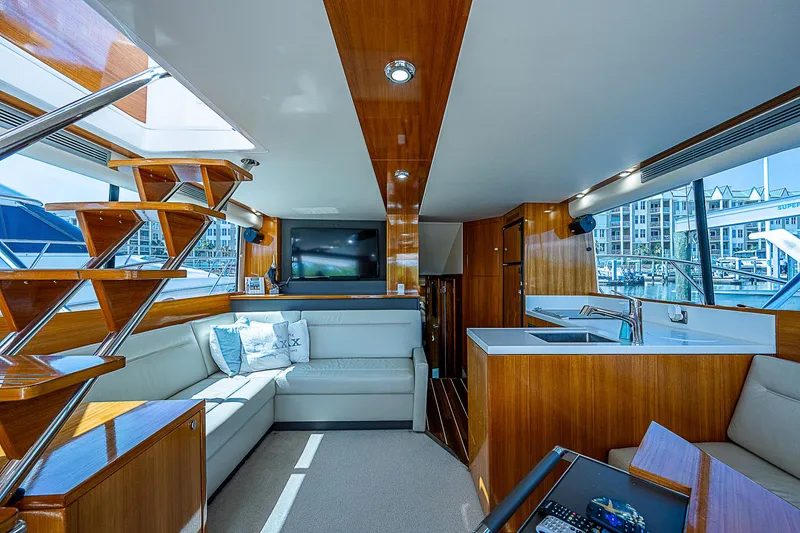 Slide: The Image of 2014 Maritimo 470 Offshore Convertible cruising under a blue sky near a bridge. - 2