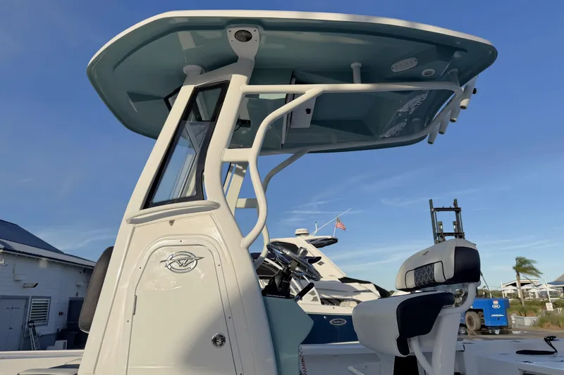 Slide: The Image of 2023 Tidewater 2410 Bay Max boat with T-top and seating, docked under clear blue sky. - 13