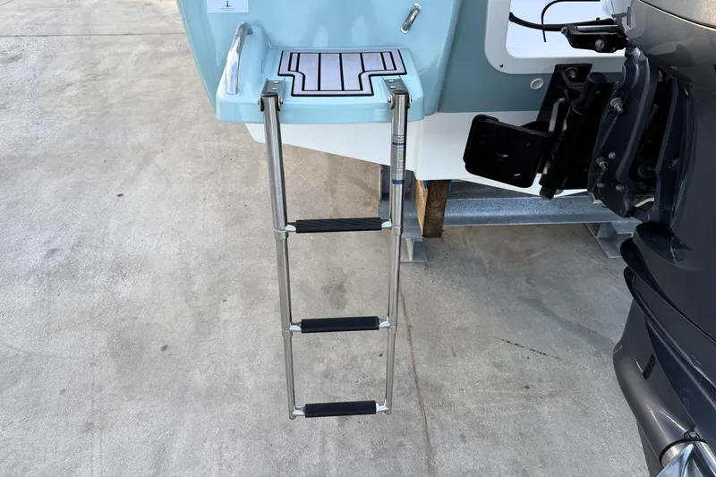 Slide: The Image of 2023 Tidewater 2410 Bay Max boat with extended swim ladder on concrete surface. - 16