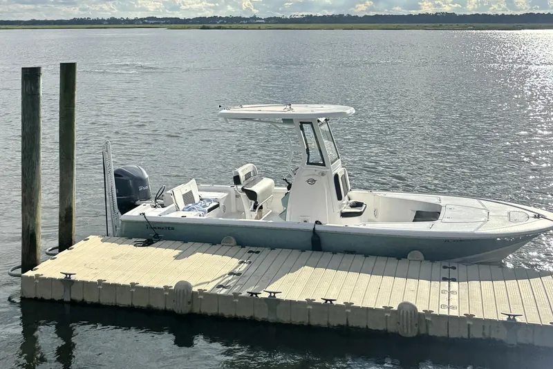Slide: The Image of 2023 Tidewater 2410 Bay Max boat docked on a sunny day. - 2