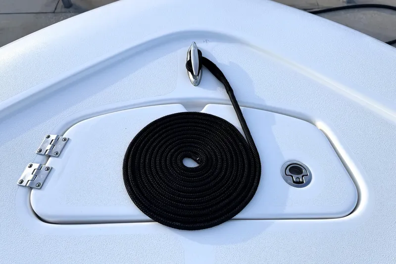 Slide: The Image of 2023 Tidewater 2410 Bay Max boat deck with coiled black rope and storage hatch. - 23