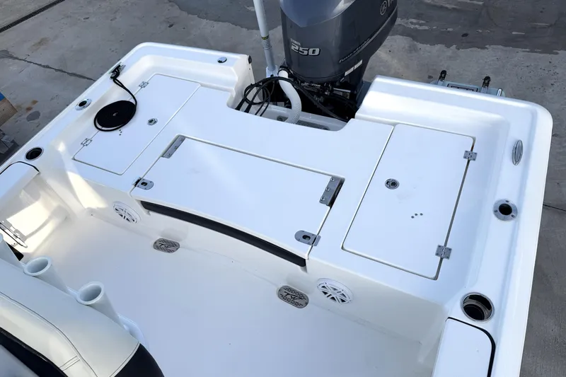 Slide: The Image of 2023 Tidewater 2410 Bay Max boat deck with Yamaha 250 engine, storage compartments, and rod holders. - 44