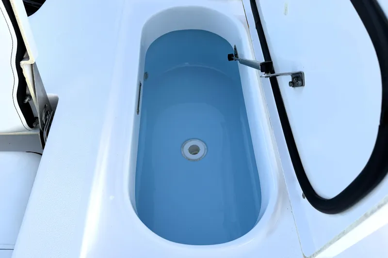 Slide: The Image of 2023 Tidewater 2410 Bay Max boat livewell with open lid, showcasing interior design. - 47