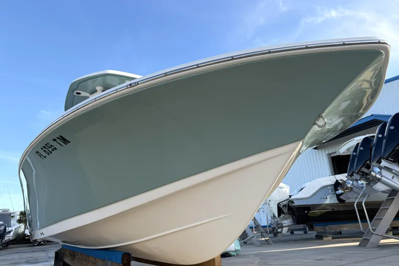 Slide: The Image of 2023 Tidewater 2410 Bay Max boat displayed outdoors, showcasing sleek hull design. - 9