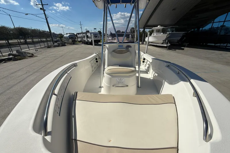 Slide: The Image of 2019 NauticStar 19 XS boat interior with seating and console, docked outdoors. - 10