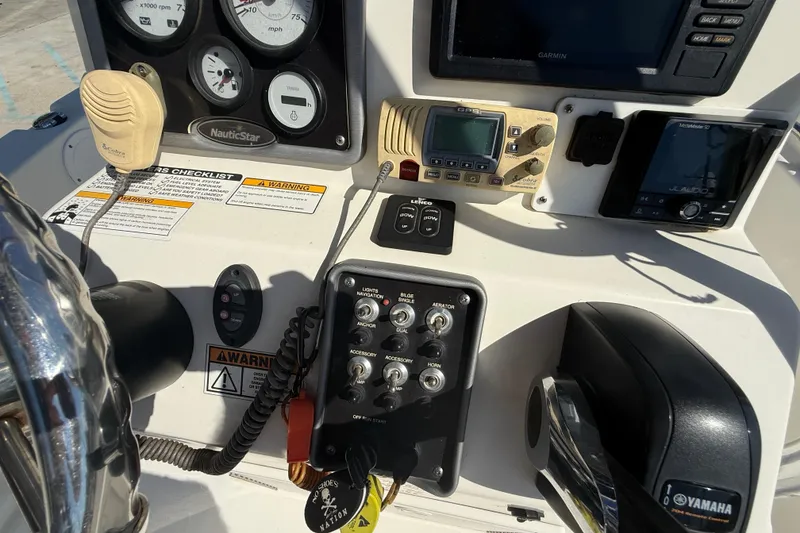 Slide: The Image of 2019 NauticStar 19 XS boat dashboard with controls, gauges, and Yamaha throttle. - 13