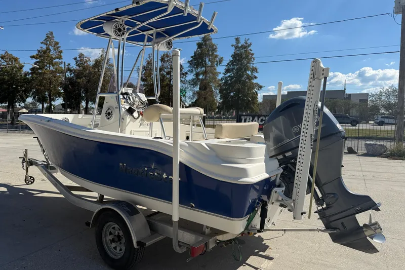 Slide: The Image of 2019 NauticStar 19 XS boat with blue hull and outboard motor on trailer. - 4