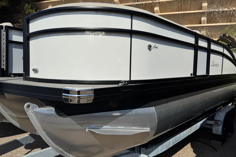 Slide: The Image of 2024 Barletta ARIA 22UC pontoon boat on trailer, sleek design, white and black exterior. - 2