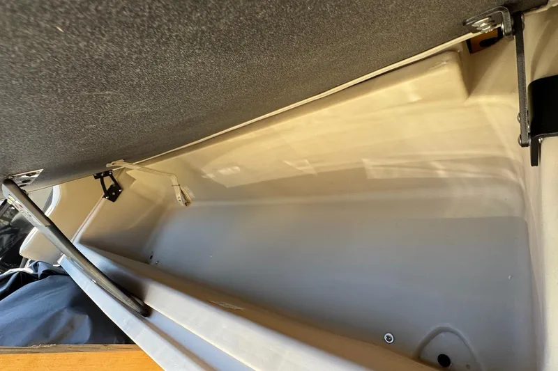 Slide: The Image of 2024 Barletta ARIA 22UC storage compartment with open lid and metal hinges. - 23