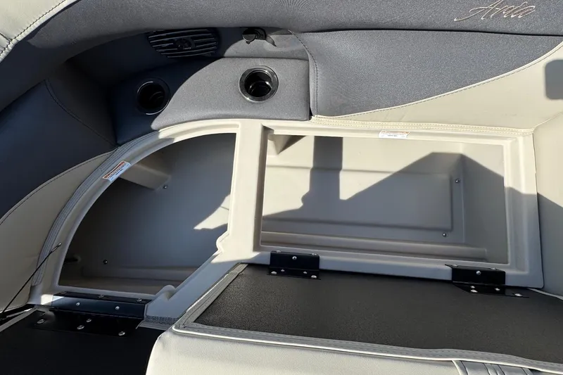Slide: The Image of 2024 Barletta ARIA 22UC boat interior storage compartment with sleek design and cup holders. - 7