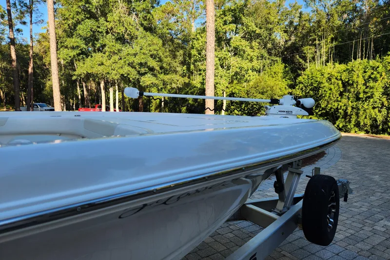 Slide: The Image of 2020 Caymas 28 HB boat on trailer, surrounded by lush greenery. - 23