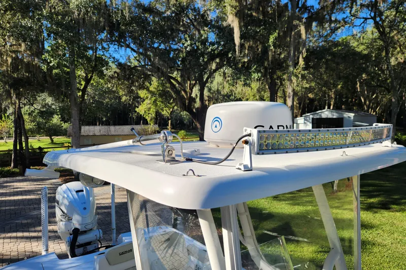 Slide: The Image of 2020 Caymas 28 HB boat with radar and light bar, surrounded by lush greenery. - 25