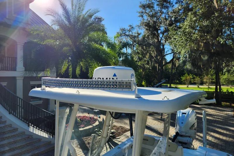 Slide: The Image of 2020 Caymas 28 HB boat with radar and light bar, surrounded by lush greenery. - 26