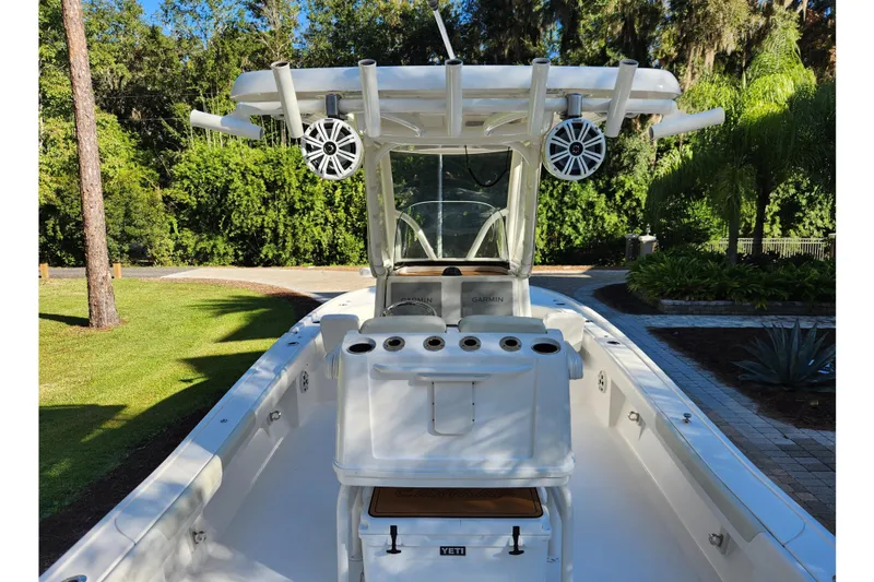 Slide: The Image of 2020 Caymas 28 HB boat with rod holders and speakers, set in a lush garden. - 27