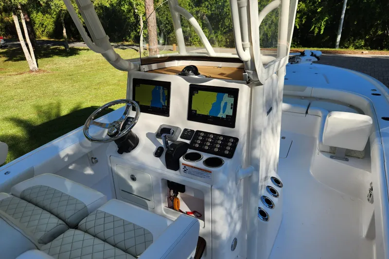 Slide: The Image of 2020 Caymas 28 HB boat cockpit with dual navigation screens and steering wheel. - 28