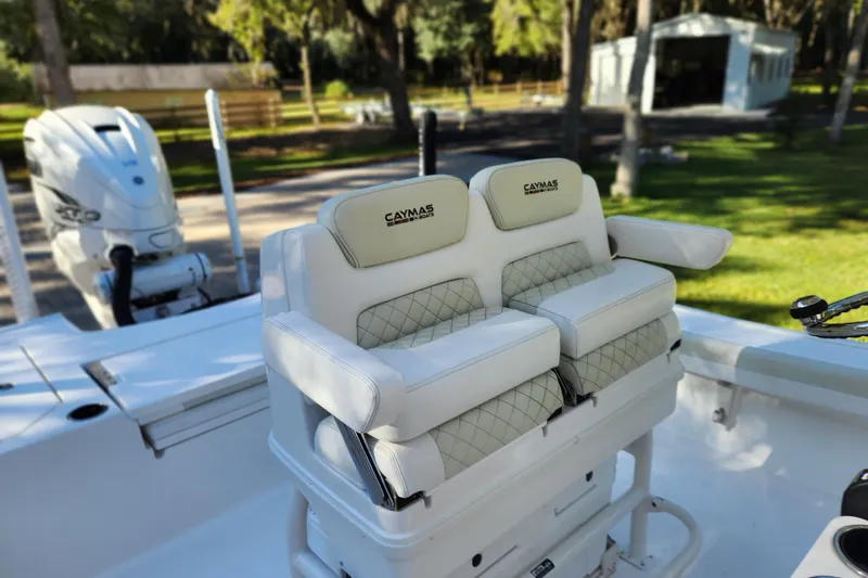Slide: The Image of 2020 Caymas 28 HB boat interior with cushioned seating and outboard motor. - 32
