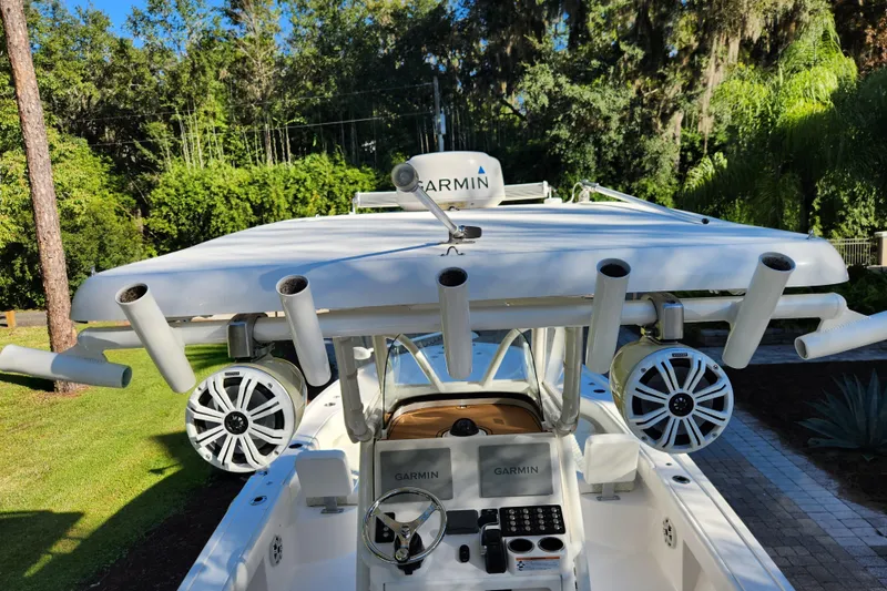 Slide: The Image of 2020 Caymas 28 HB boat with Garmin electronics and rod holders, surrounded by lush greenery. - 36