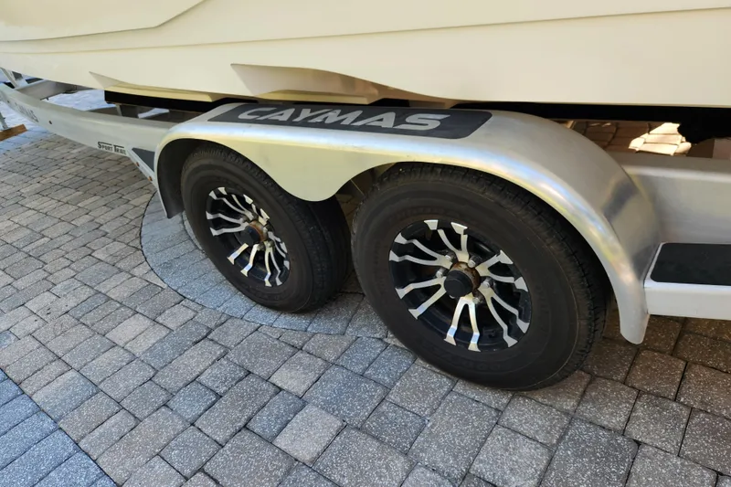 Slide: The Image of Trailer wheels of a 2020 Caymas 28 HB boat on a paved surface. - 65