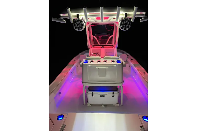 Slide: The Image of 2020 Caymas 28 HB boat interior with vibrant LED lighting and fishing rod holders. - 70