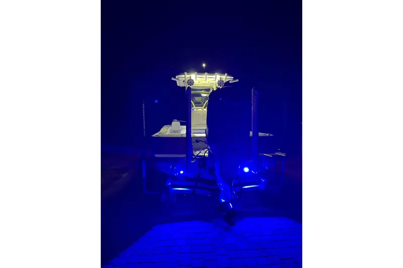 Slide: The Image of 2020 Caymas 28 HB boat illuminated with blue lights at night. - 71