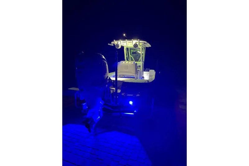 Slide: The Image of 2020 Caymas 28 HB boat illuminated with blue and white lights at night. - 72