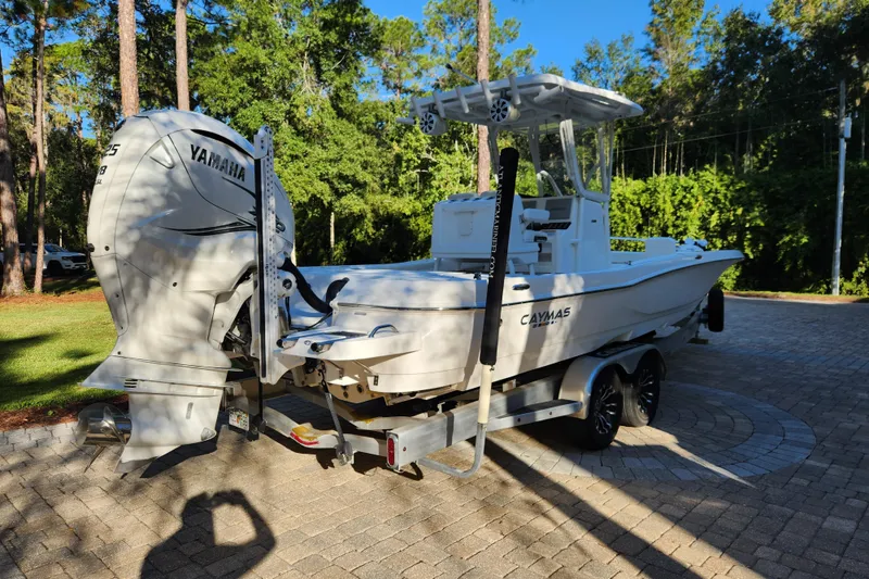 Slide: The Image of 2020 Caymas 28 HB boat on trailer with Yamaha engine, parked in a wooded area. - 9