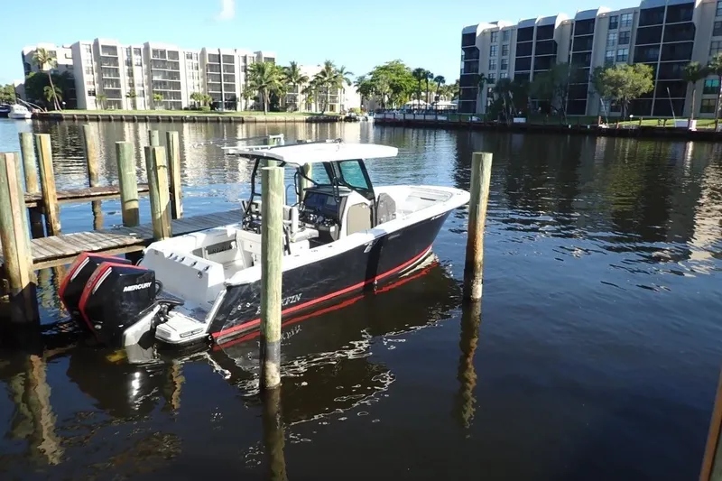 Slide: The Image of 2022 Blackfin 272 CC boat docked in a marina with waterfront buildings. - 1