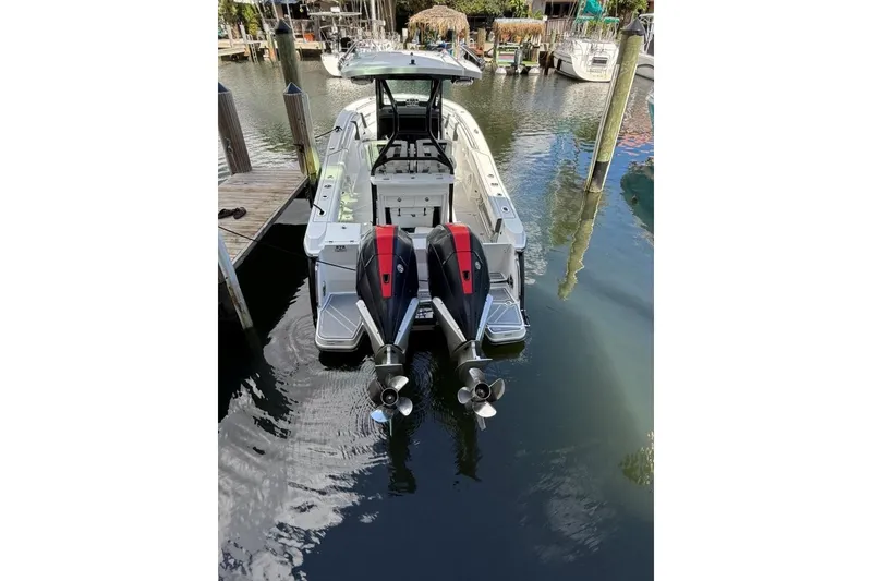 Slide: The Image of 2022 Blackfin 272 CC boat bow view, featuring sleek white design on calm water. - 20