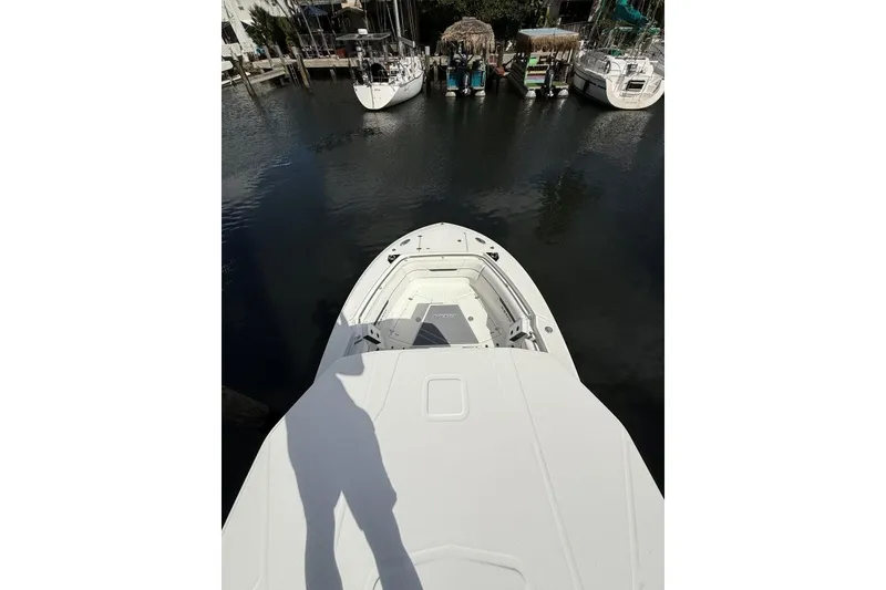 Slide: The Image of 2022 Blackfin 272 CC boat docked in a serene canal setting. - 22