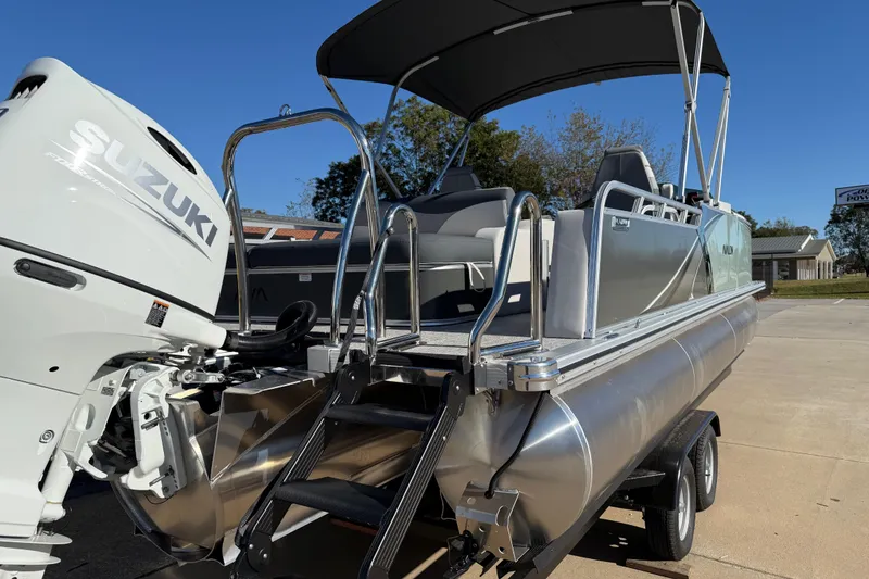 Slide: The Image of 2026 Avalon LSZ Versatile Rear Bench pontoon boat with Suzuki engine, parked on trailer. - 8