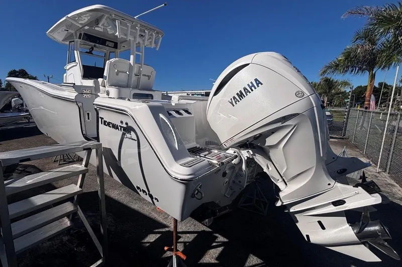Slide: The Image of 2026 Tidewater 302 CC Adventure boat with Yamaha engine, parked outdoors under clear blue sky. - 10