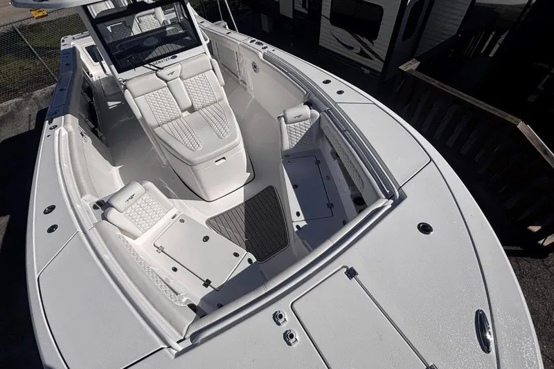 Slide: The Image of 2026 Tidewater 302 CC Adventure boat interior with white seating and storage compartments. - 11