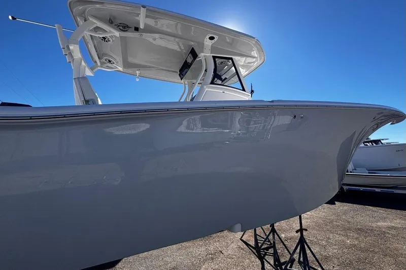 Slide: The Image of 2026 Tidewater 302 CC Adventure boat under clear blue sky, side view. - 19