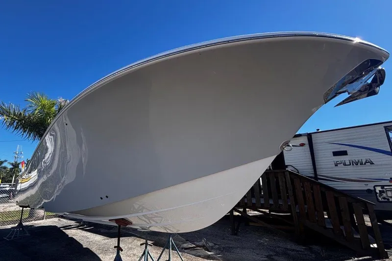 Slide: The Image of 2026 Tidewater 302 CC Adventure boat displayed outdoors under clear blue sky. - 20