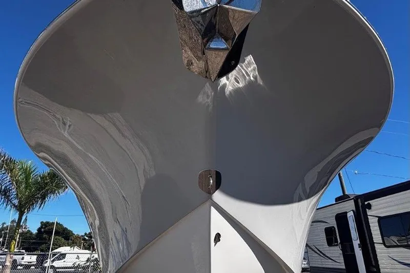 Slide: The Image of 2026 Tidewater 302 CC Adventure boat hull, viewed from below, under clear blue sky. - 21