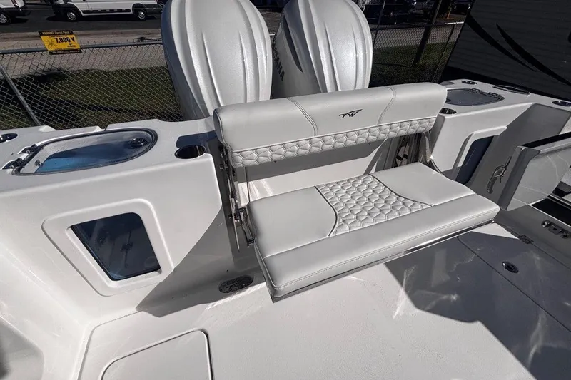 Slide: The Image of 2026 Tidewater 302 CC Adventure boat interior with white seating and storage compartments. - 25