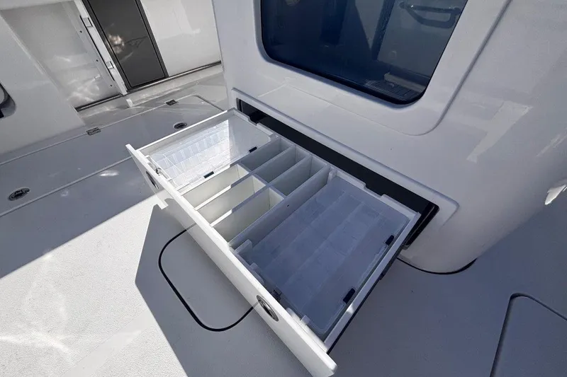 Slide: The Image of 2026 Tidewater 302 CC Adventure boat with open storage compartment, showcasing organized interior. - 32