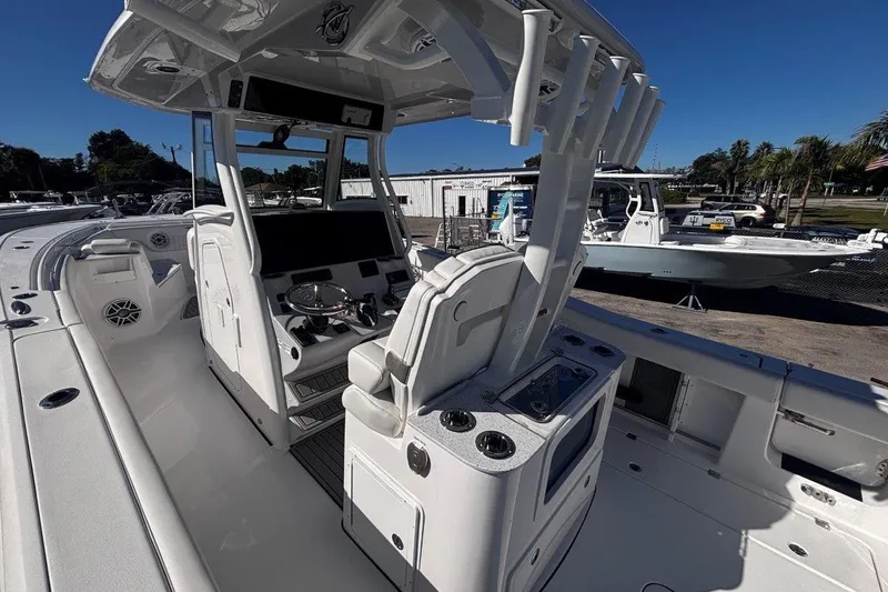 Slide: The Image of 2026 Tidewater 302 CC Adventure boat interior with helm and seating, docked outdoors. - 34