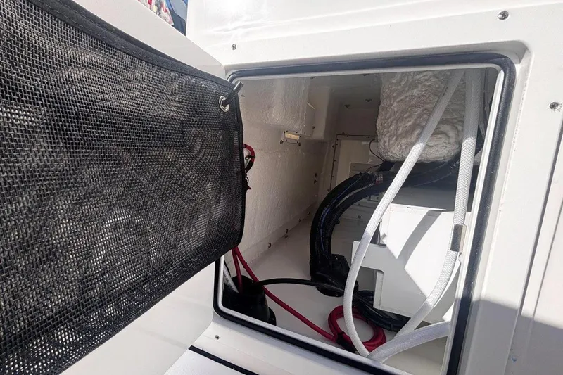 Slide: The Image of Interior view of 2026 Tidewater 302 CC Adventure boat compartment with wiring and storage. - 35