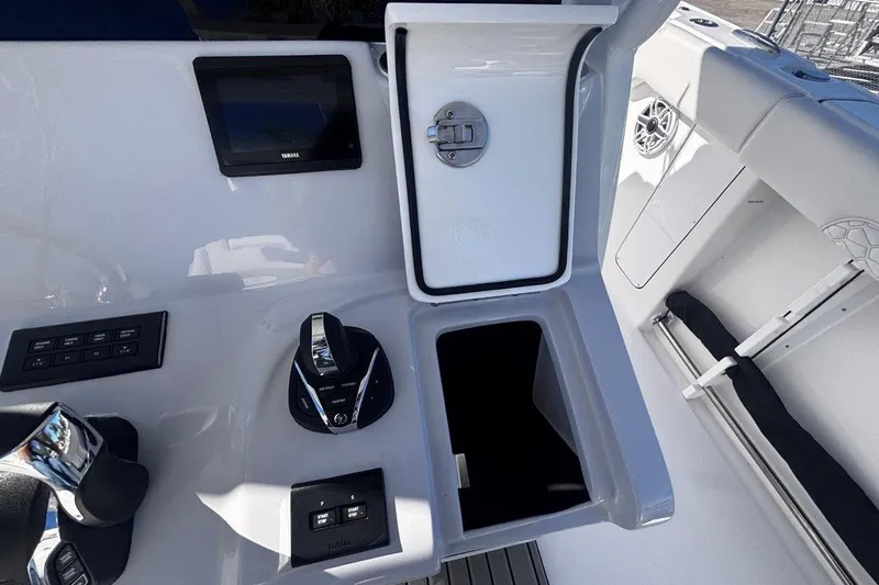 Slide: The Image of 2026 Tidewater 302 CC Adventure boat console with controls and storage compartment. - 44