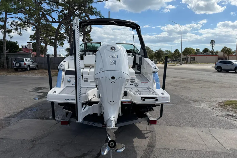 Slide: The Image of 2024 Chaparral 270 OSX boat with powerful outboard engine, parked outdoors under a cloudy sky. - 2