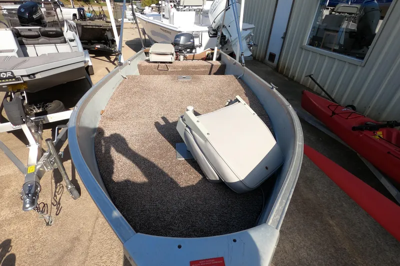 Slide: The Image of 1994 MIRRO CRAFT 15 boat with carpeted interior, parked outdoors near other boats. - 4