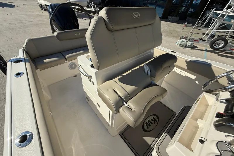 Slide: The Image of 2022 Key West 239 FS boat interior with beige seating and steering console. - 13