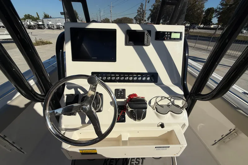 Slide: The Image of 2022 Key West 239 FS boat dashboard with steering wheel and navigation controls. - 16